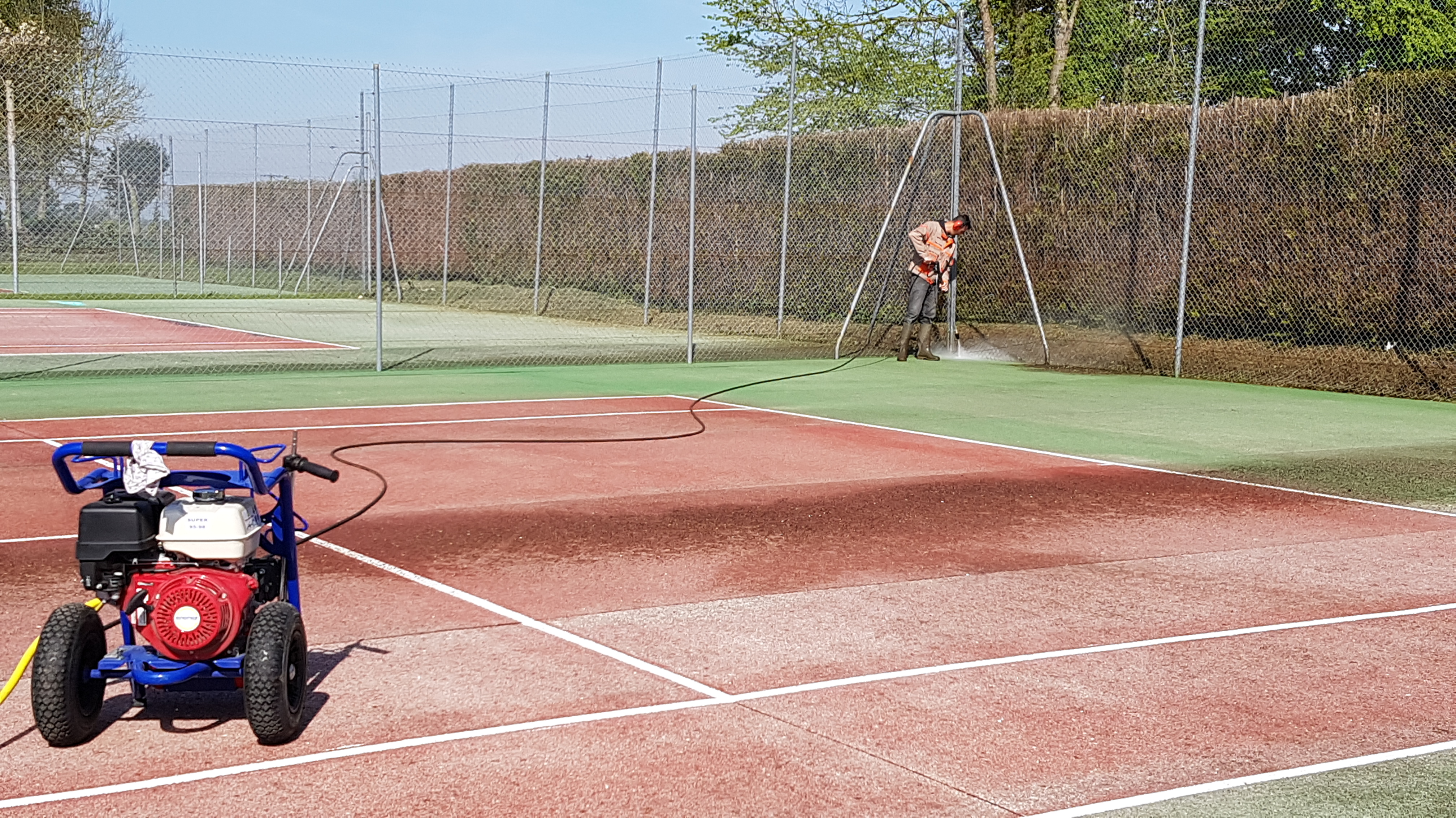 Nettoyage démoussage d'un court de tennis en béton poreux