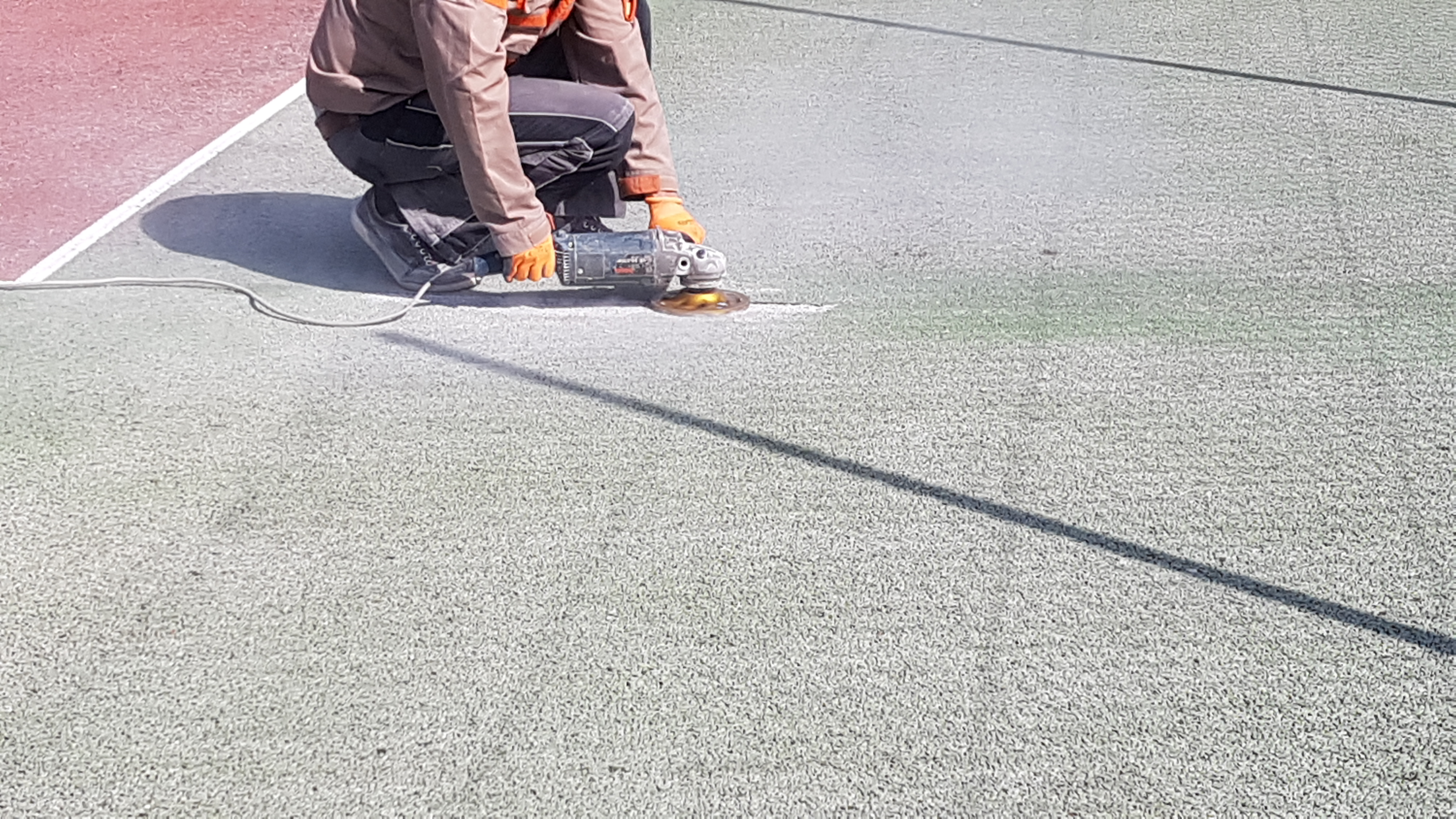 Travaux de rabotage ( ponçage) sur un court de tennis