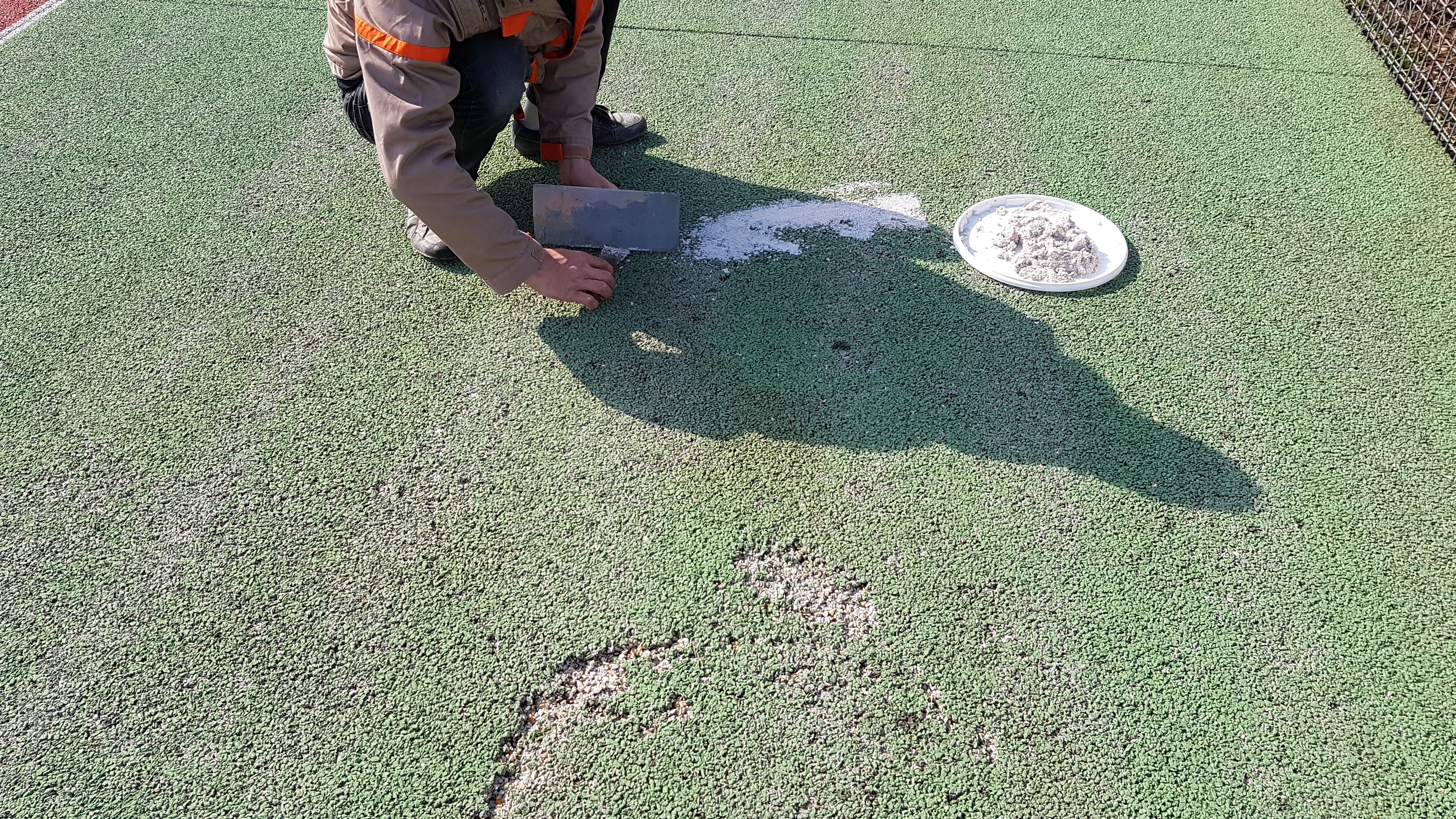 Traitement des éclats sur un court de tennis en béton poreux
