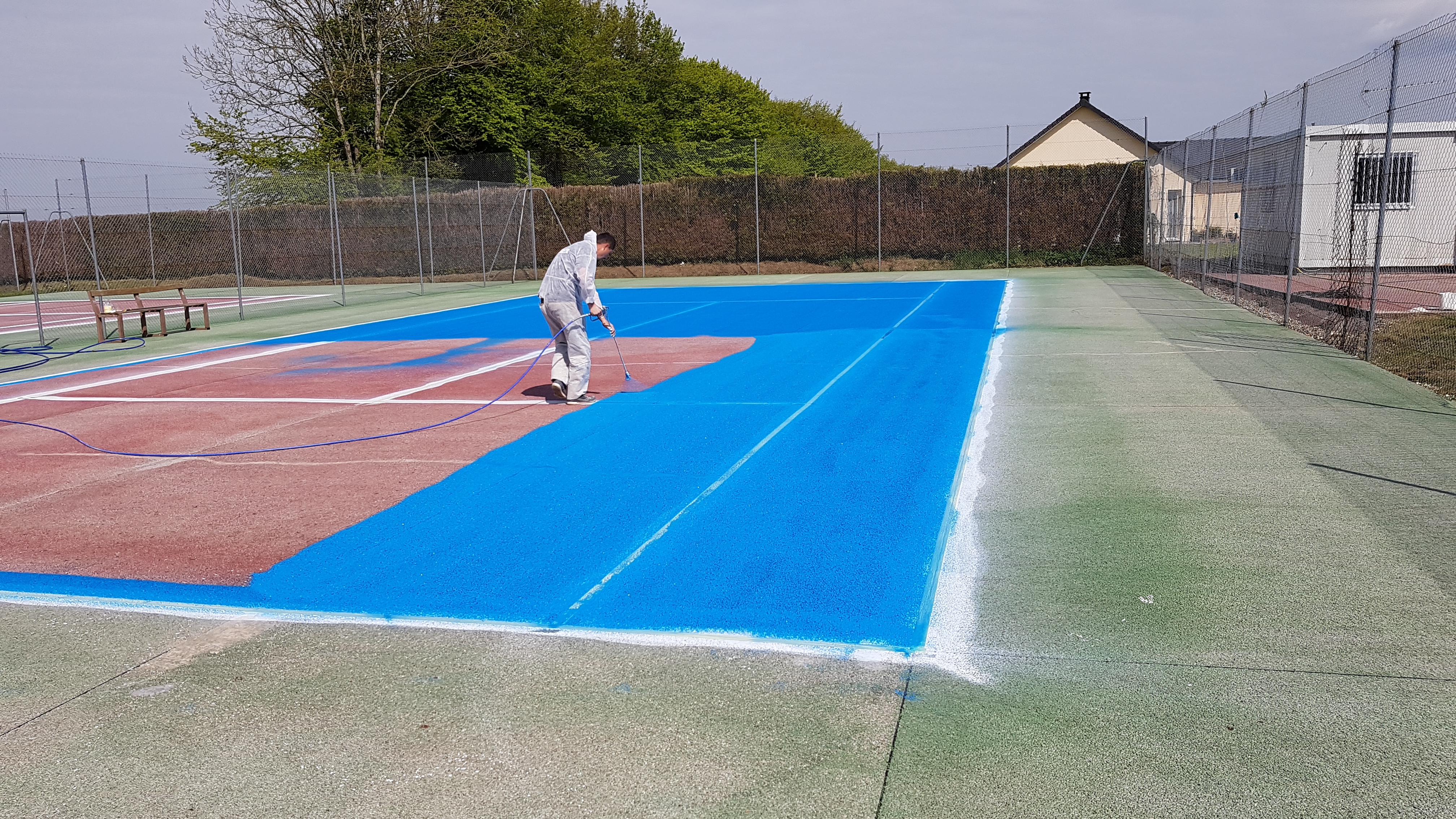 Application de peinture sur un court de tennis en béton poreux